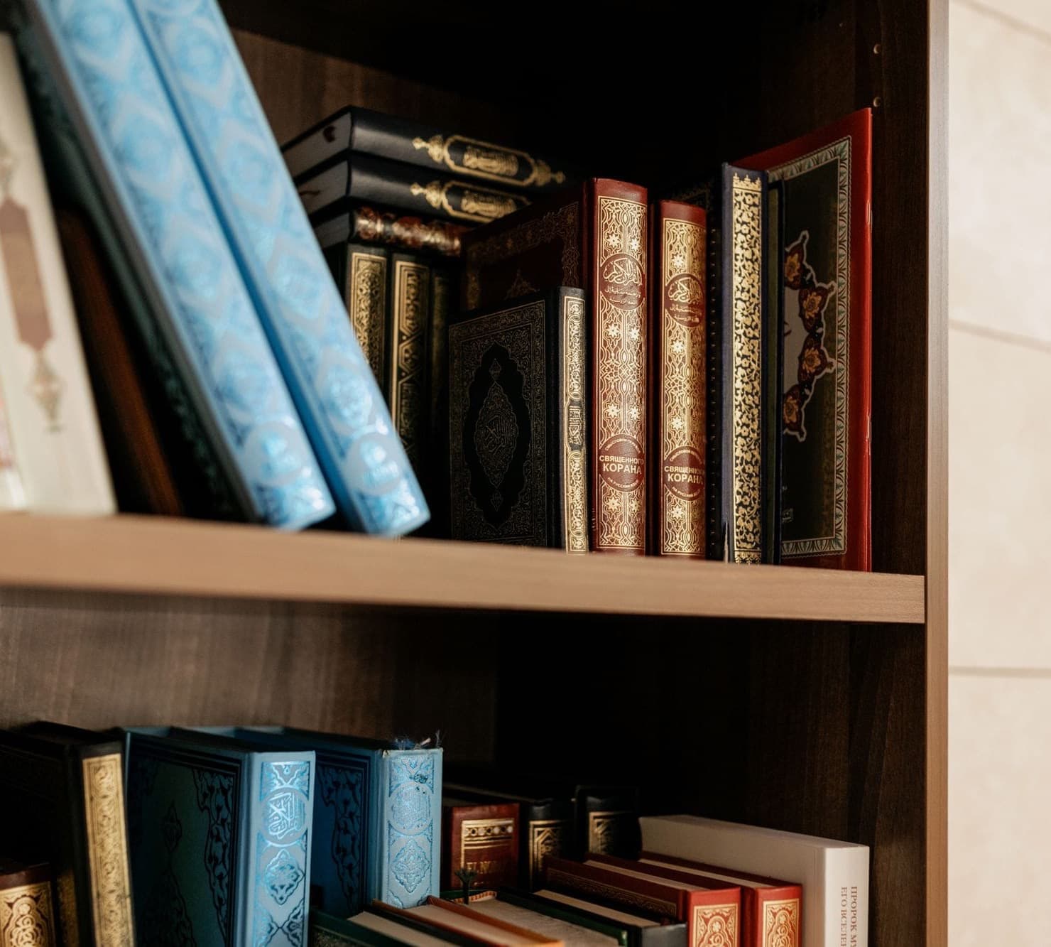 Rows of Qur'an volumes shelved in a library.